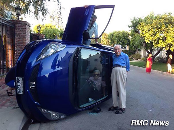 Пожилая пара делает селфи на фоне перевернувшейся машины. Женщина пока еще зажата внутри забавно, независимость, общественное мнение, решимость