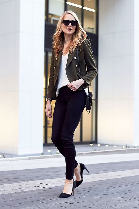 Девушка в черных джинсах скинни, белый топ и жакет в стиле милитари
