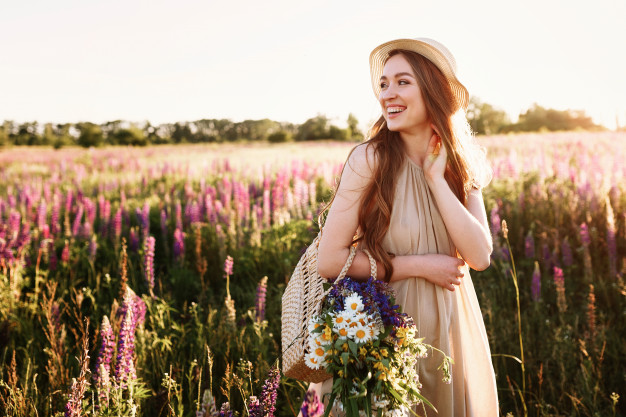 Счастливый молодая девушка, ходить в поле цветов на закате ...