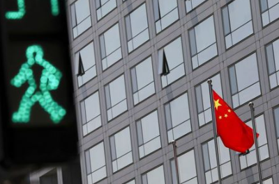 FILE PHOTO: A Chinese national flag flutters outside the China Securities Regulatory Commission (CSRC) building on the Financial Street in Beijing, China July 9, 2021. REUTERS/Tingshu Wang/File Photo