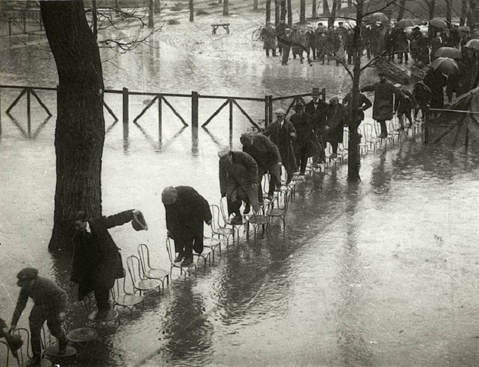Во время наводнения парижане передвигались по городу при помощи стульев. Франция, 1924 год.