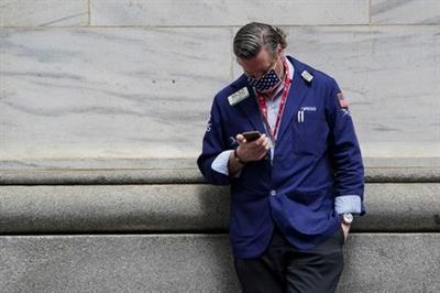 A trader takes a break outside the New York Stock Exchange amid the coronavirus disease (COVID-19) pandemic in the Manhattan borough of New York City, New York, U.S., April 16, 2021. REUTERS/Carlo Allegri
