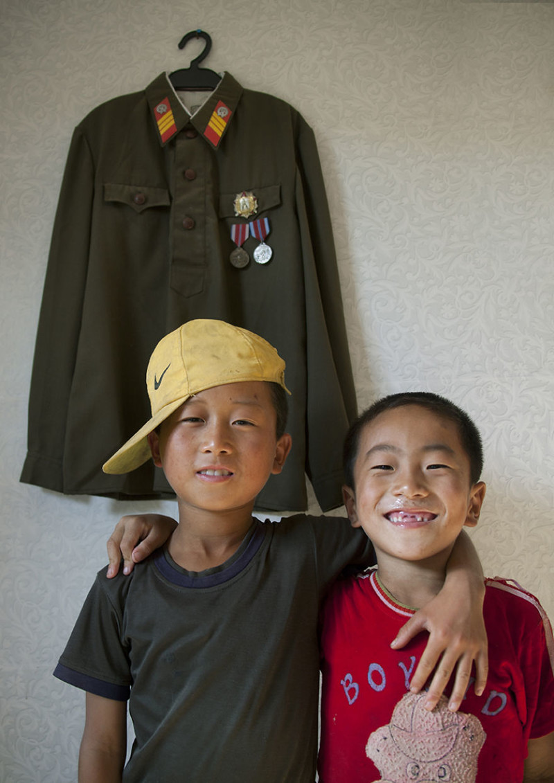13. Мальчики на фоне военной формы  житель, северная корея, улыбка, фотография