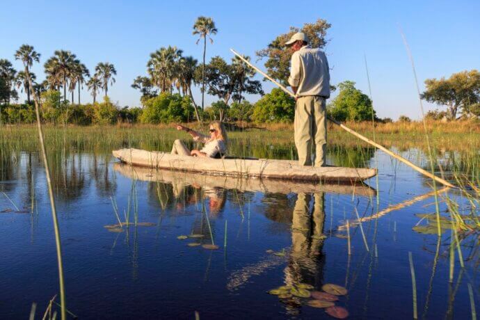 мужчина и женщина в деревянной лодке на реке