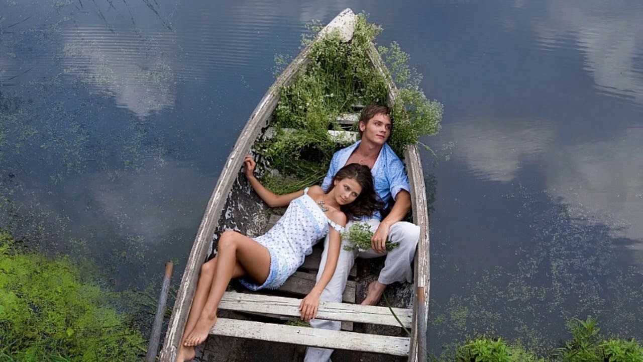 Двое подошли к реке. Влюбленные в лодке. Фотосессия в лодке. Необычные места для фотосессии. Парень с девушкой в лодке.