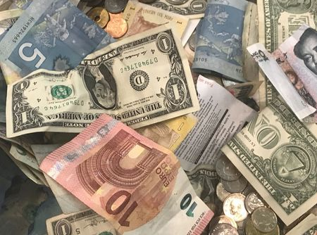 FILE PHOTO: U.S. dollars and other world currencies lie in a charity receptacle at Pearson international airport in Toronto, Ontario, Canada June 13, 2018. REUTERS/Chris Helgren/File Photo