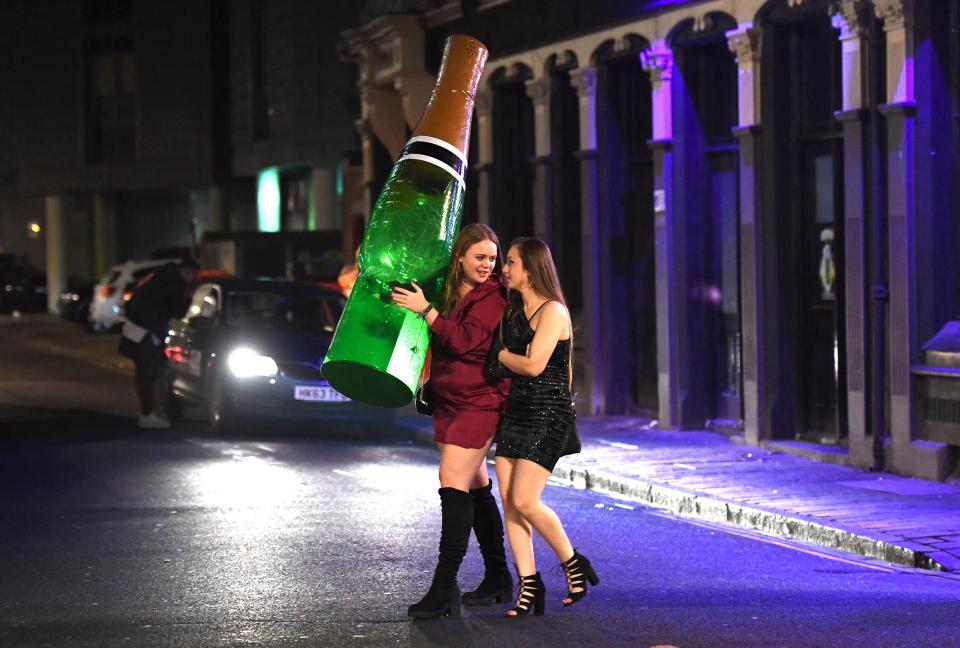 Revellers in Portsmouth leave the club clutching an enormous bottle of champagne