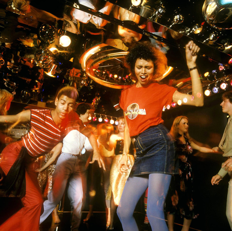 Группа молодежи отрывается на зеркальном танцполе, около 1978 года Веселые, люди, эпоха