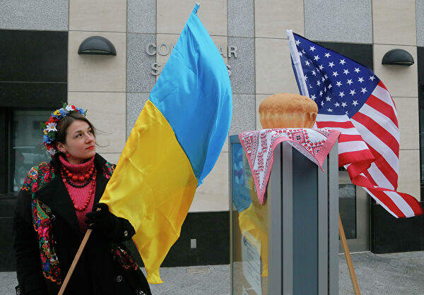 Женщина держит флаг Украины посольством США в Киеве