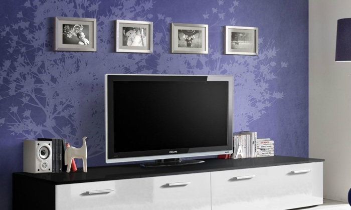 Фиолетовые обои создают в зоне для просмотра телевизора необычную композицию. 