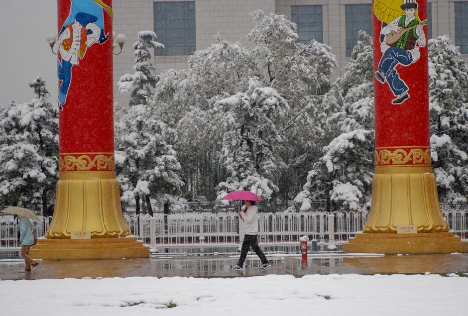 2) Пешеходы под снегопадом идут через площадь Тяньаньмэнь в Пекине. 