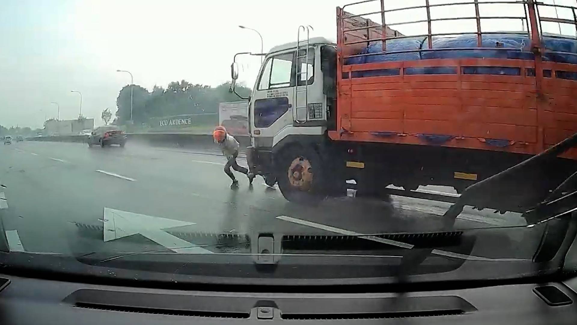 Малазийский мотоциклист отскочил от колес грузовика за секунду до столкновения