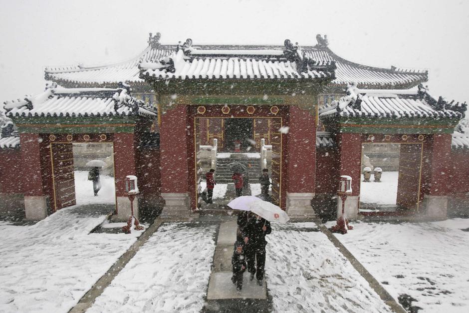 9)  Пекинцы под обильным снегопадом возле знаменитого пекинского Храма Неба