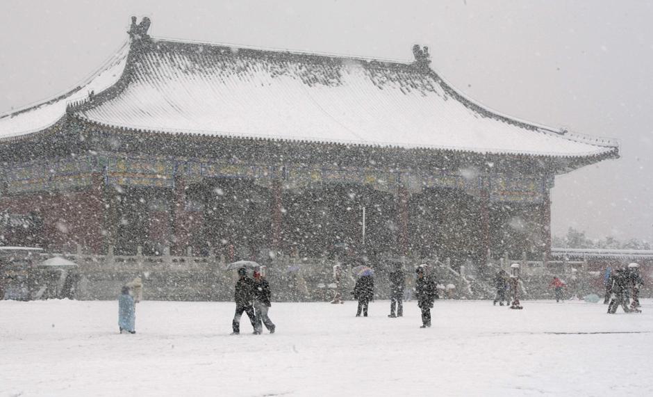 7) Пекинцы гуляют под густым снегом возле знаменитого пекинского Храма Неба