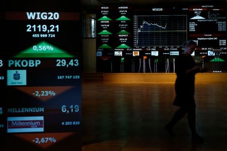 A woman passes by stock exchange display panels in Warsaw, Poland October 26, 2015. Poland's benchmark equity index WIG20 reversed early falls and rose 0.3 percent after the main opposition party Law and Justice won weekend parliamentary elections. The party confirmed its plan to introduce a banking tax as of January 2016, which hit bank stocks like PKO BP and mBank. REUTERS/Kacper Pempel