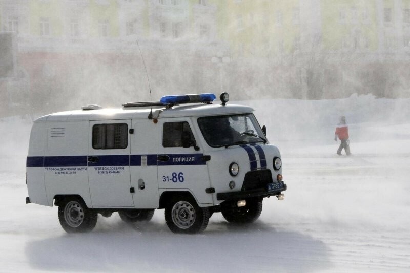 Норильск. Полицейский автомобиль на одной из улиц во время ветреной погоды