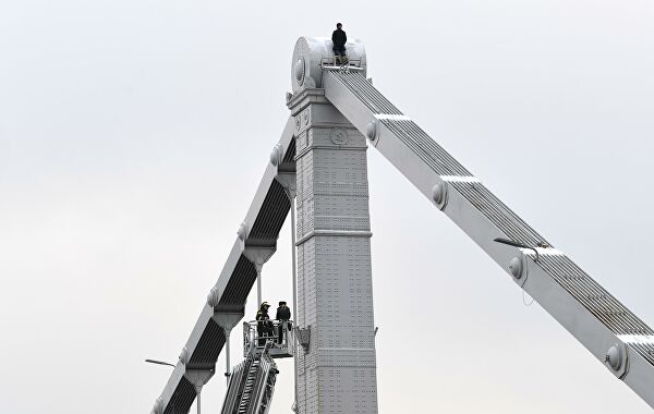 Сотрудники МЧС РФ пытаются снять мужчину с конструкции Крымского моста в Москве