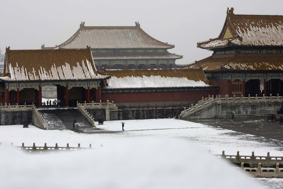 10) Посетители заходят в Запретный город под снегопадом в Пекине. 
