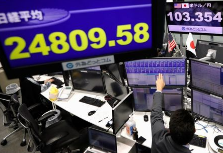 An employee of the foreign exchange trading company works in front of monitors showing Japan's Nikkei share average and the Japanese yen exchange rate against the U.S. dollar at a dealing room in Tokyo, Japan November 9, 2020. REUTERS/Issei Kato