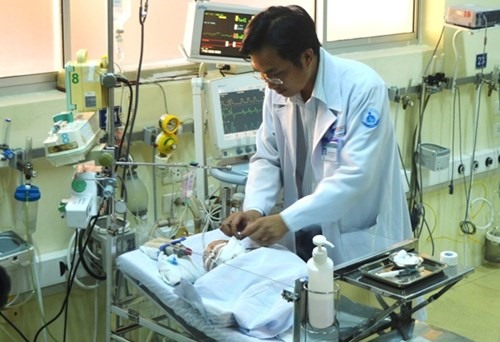 Врач в Педиатрической больнице Ho Chi Minh City (HCMC) осматривает ребенка после операции удаления большой опухоли