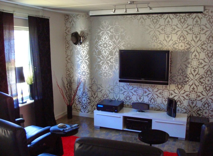 Гостиная комната в стиле минимализма с роскошными обоями в зоне для просмотра телевизора. 