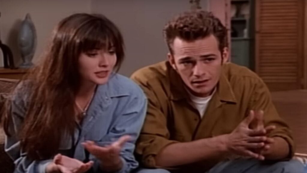 Dylan (Luke Perry) sits next to Brenda (Shannen Doherty) as the two discuss Dylan being accused of cheating on his SATs. - Fox Paramount+ Screenshot