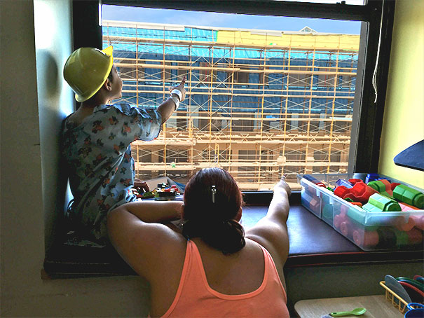 строитель ставит фигурку Уолдо для детей из больницы напротив