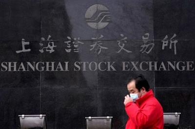FILE PHOTO: A man walks past the Shanghai Stock Exchange building at the Pudong financial district in Shanghai, China, February 3, 2020. REUTERS/Aly Song