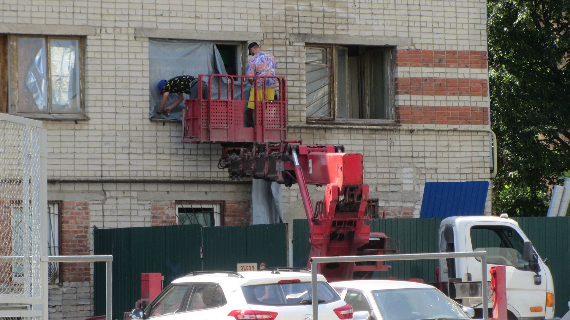 Рабочие занавешивают окна. Белгород, 03.07.2022 г.