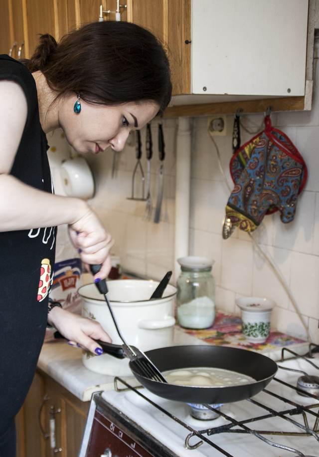 Russian cooking. Женщина жарит блины. Девушка готовит блинчики. Девушка жарит блинчики. На кухне жарятся блинчики.