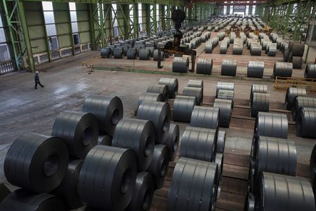 A worker walks by steel rolls at the Chongqing Iron and Steel plant in Changshou, Chongqing, China August 6, 2018. Picture taken August 6, 2018. REUTERS/Damir Sagolj