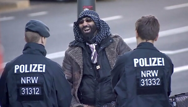 Мигрант смеется в лицо полиции Германии, логично, ведь у него прав больше чем у любого коренного немца. Фото из открытых источников.