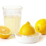 Лимонный сок, соковыжималка и лимоны