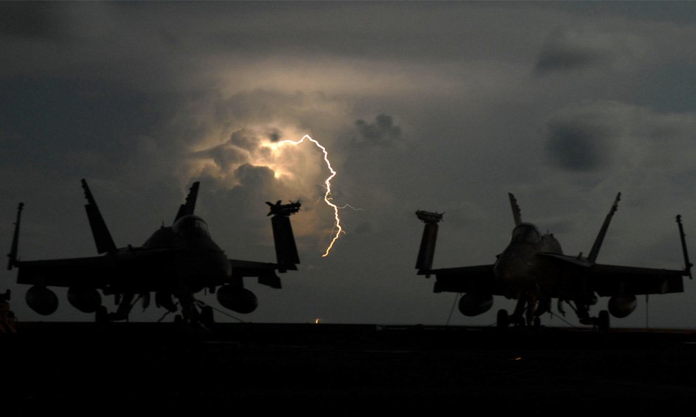 Разряды молнии за двумя палубными истребителями-бомбардировщиками F/A-18C Hornet