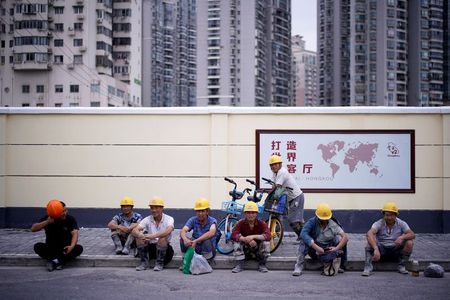 Construction workers rest in a street, following the coronavirus disease (COVID-19) outbreak, in Shanghai, China July 16 2020. REUTERS/Aly Song