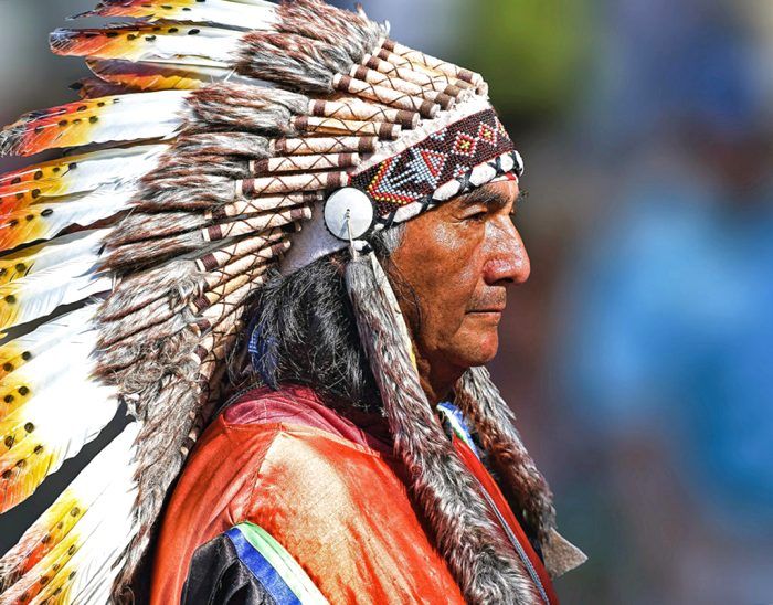 Представитель племени сиу в аутентичной одежде с венцом из перьев на голове. /Фото: irinatraveling.com