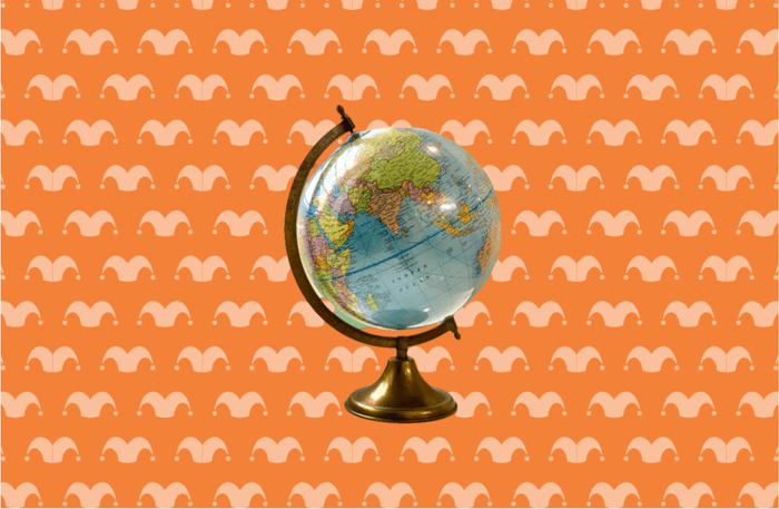 A globe in a stand against an orange background