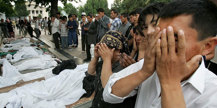Люди молятся около тел жертв расстрела в Андижане. 14 мая 2005 года
