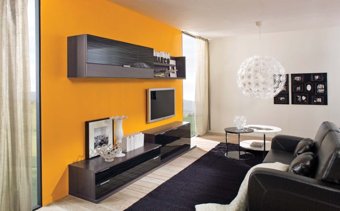 Зона для просмотра телевизора выделенная контрастными желтыми обоями, которые ярким пятном выделяются в интерьере гостиной. 