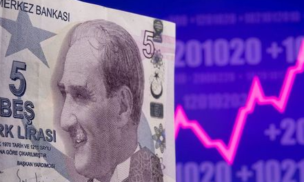 A Turkish lira banknote is seen in front of displayed stock graph in this illustration taken May 7, 2021. REUTERS/Dado Ruvic/Illustration