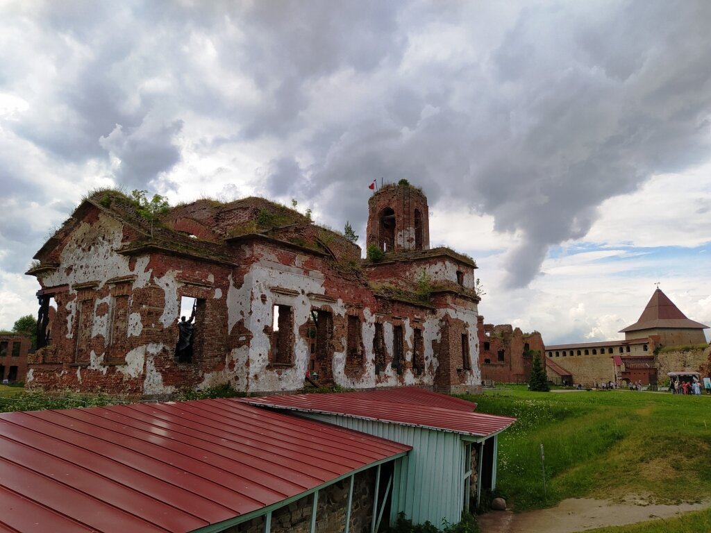 На переднем плане, под красной крышей, раскопанный фрагмент крепостной стены первой каменной крепости Новгородского княжества