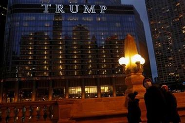 People wearing protective face masks, as the global outbreak of the coronavirus disease (COVID-19) continues, walk by Trump International Hotel and Tower in Chicago, Illinois, U.S., December 6, 2020. REUTERS/Shannon Stapleton 