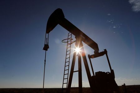 The sun is seen behind a crude oil pump jack in the Permian Basin in Loving County, Texas, U.S., November 22, 2019. Picture taken November 22, 2019. REUTERS/Angus Mordant