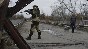 Ополченец на отремонтированном мосту, соединяющем подконтрольные государству и повстанцам территории