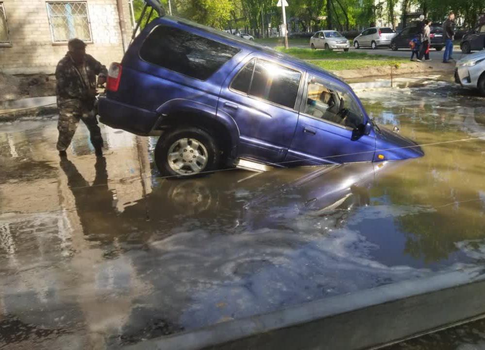 В Хабаровске Toyota Hilux наполовину провалился в огромную яму под лужей