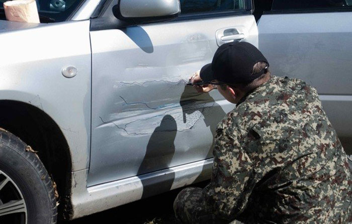 Водитель разрисовывает свой автомобиль.