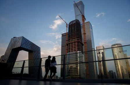 People look at the skyline of the Central Business District in Beijing, China, April 16, 2020. REUTERS/Thomas Peter