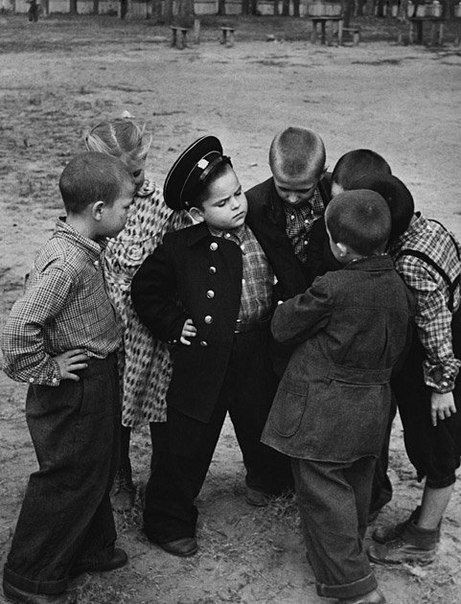 Первоклассник показывает друзьям школьную форму, 1955 год, СССР историческое фото, история