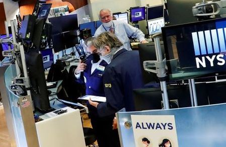 Traders wearing masks work, on the first day of in person trading since the closure during the outbreak of the coronavirus disease (COVID-19) on the floor at the New York Stock Exchange (NYSE) in New York, U.S., May 26, 2020. REUTERS/Brendan McDermid/File Photo