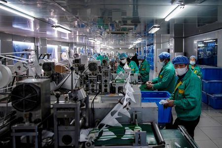 Workers are seen on a production line manufacturing masks at a factory in Shanghai, China January 31, 2020. Picture taken January 31, 2020. REUTERS/Aly Song